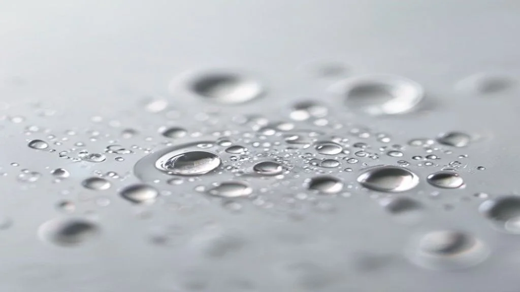 Wassertropfen auf glatter Oberfläche gruppieren sich um einen zentralen Tropfen — Visualisierung der Konsolidierung mehrerer Marken-Domains zu einer Entität.