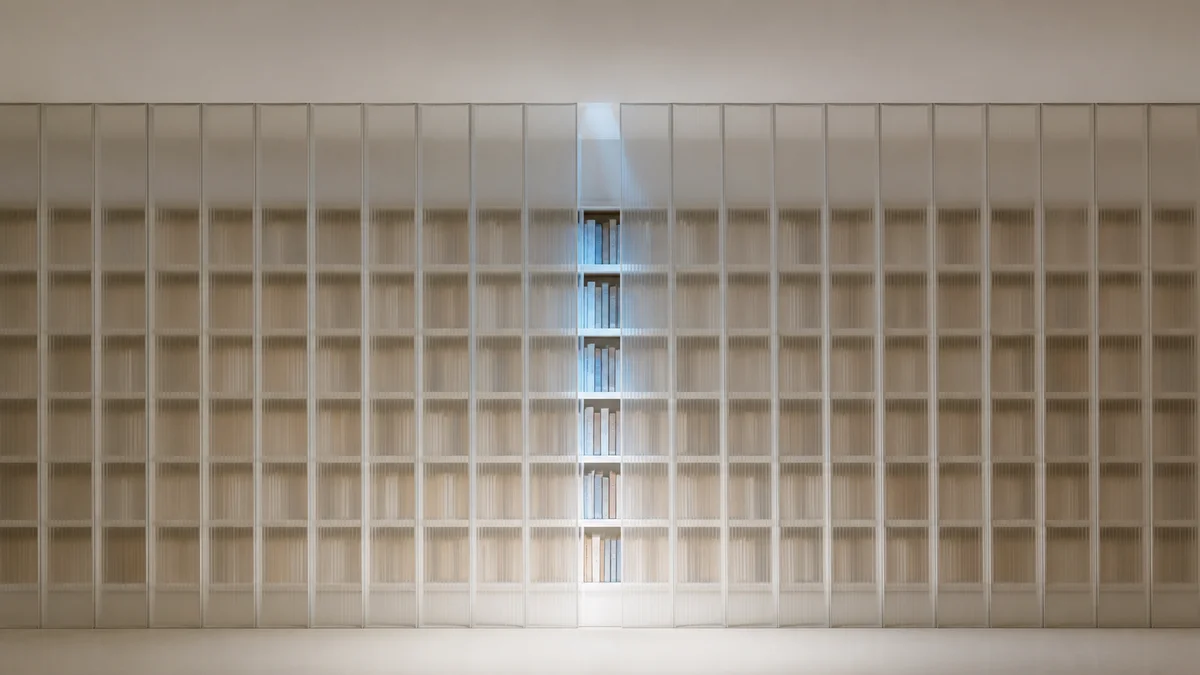 Eine halbtransparente Lamellenwand gibt durch eine schmale, kühlblau beleuchtete Öffnung den Blick auf Bücher frei und symbolisiert den kontrollierten Zugang von KI-Bots zu Webinhalten.